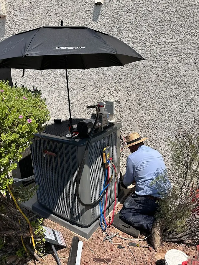 HVAC technician performing outdoor AC maintenance in Kuna