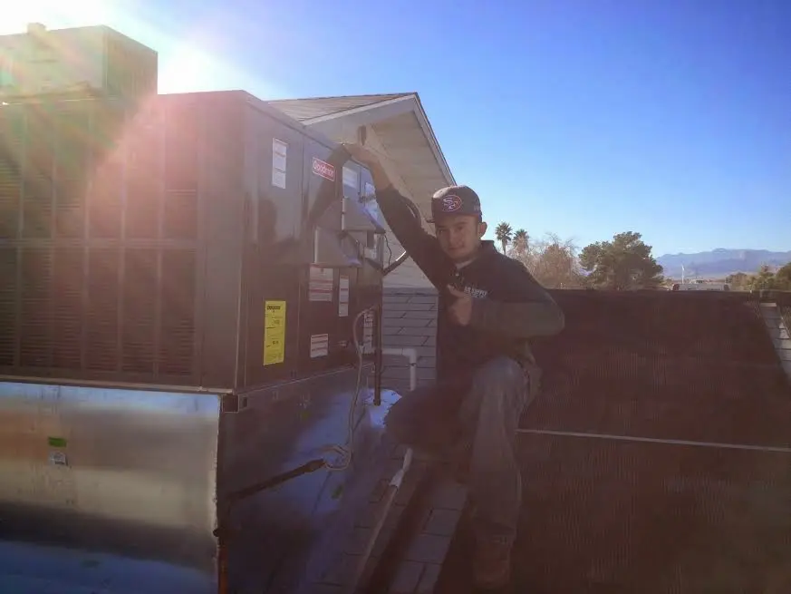 HVAC technician performing Heat Pump Repair on a rooftop unit in Kuna